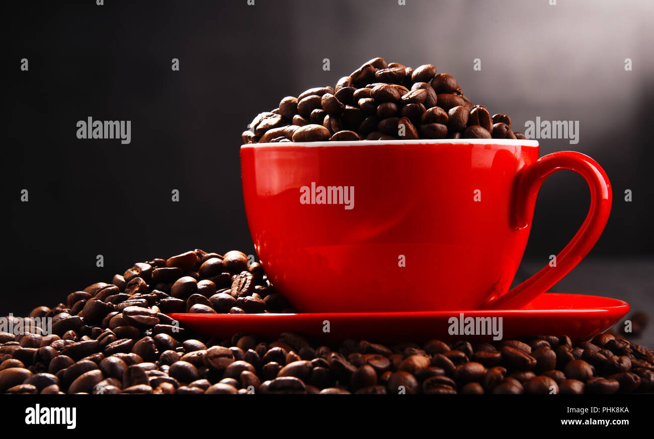 Composizione con Rosso tazza di caffè e fagioli. Foto Stock