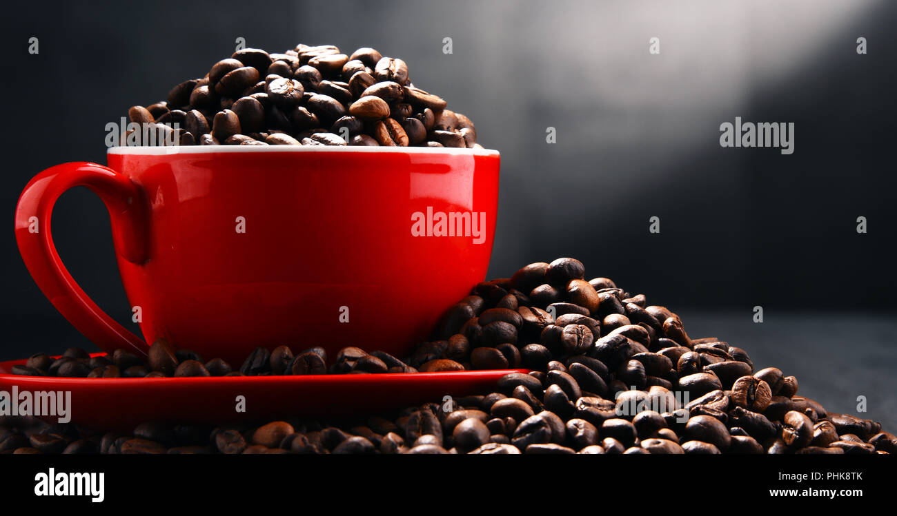 Composizione con Rosso tazza di caffè e fagioli. Foto Stock