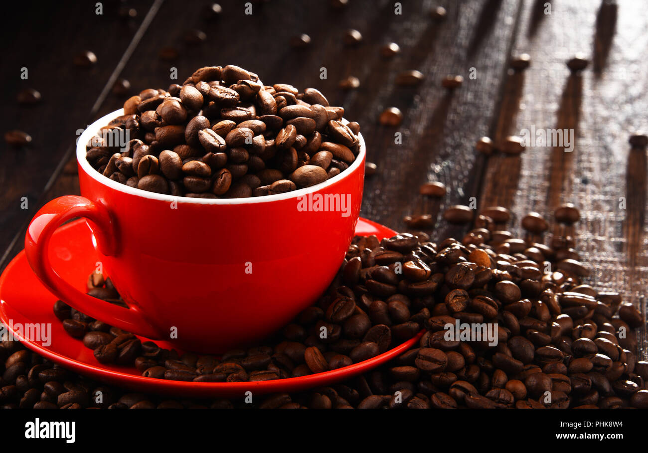 Composizione con Rosso tazza di caffè e fagioli. Foto Stock