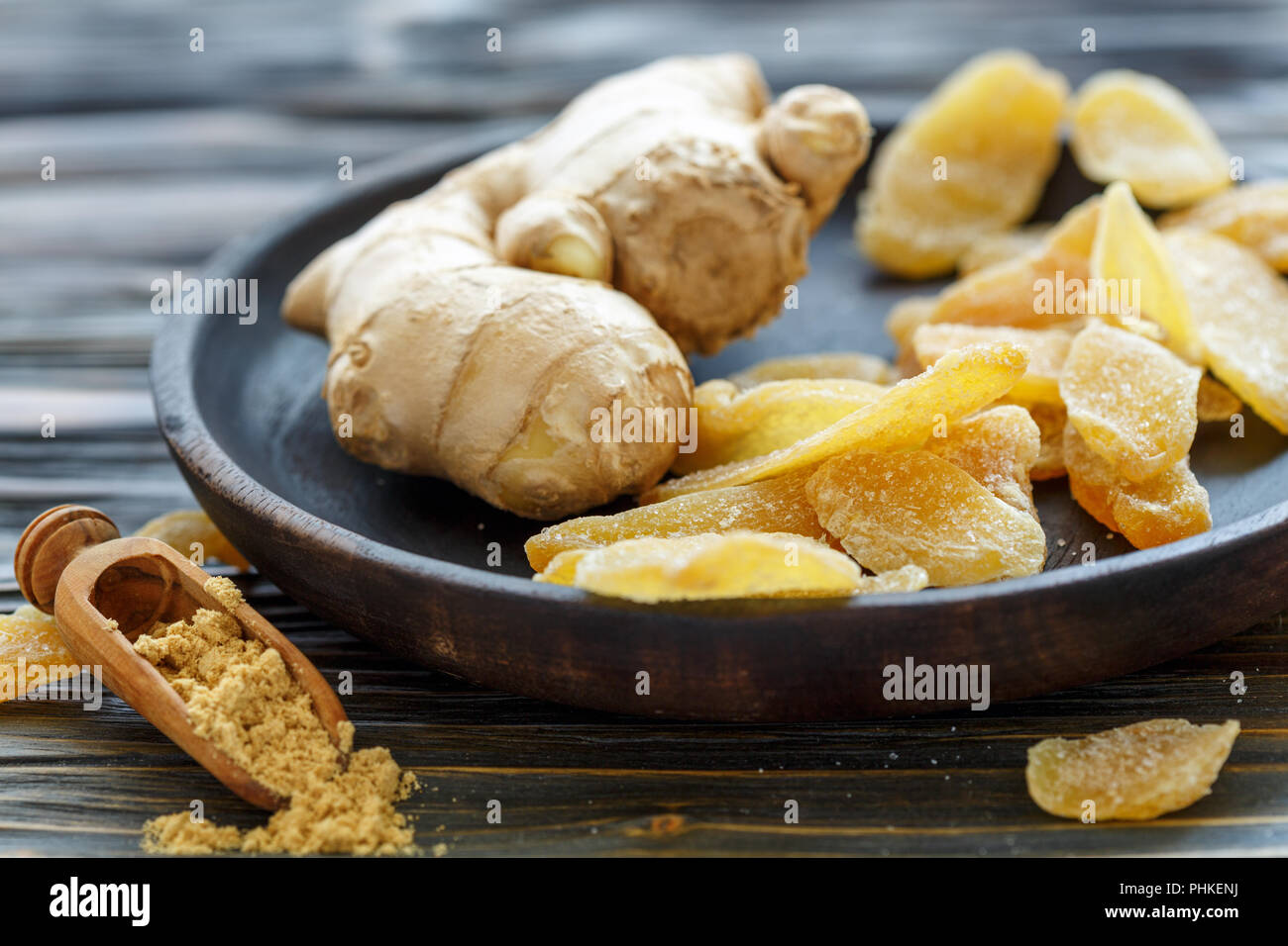Radice di Zenzero e zenzero candito su una lastra di legno. Foto Stock