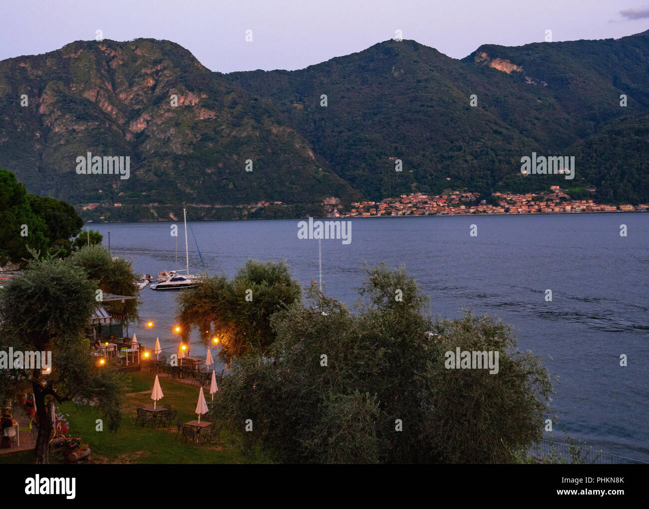 Il fascino del Lago di Como con i villaggi dominato da alte montagne coperte da boschi verdi,Italia Foto Stock