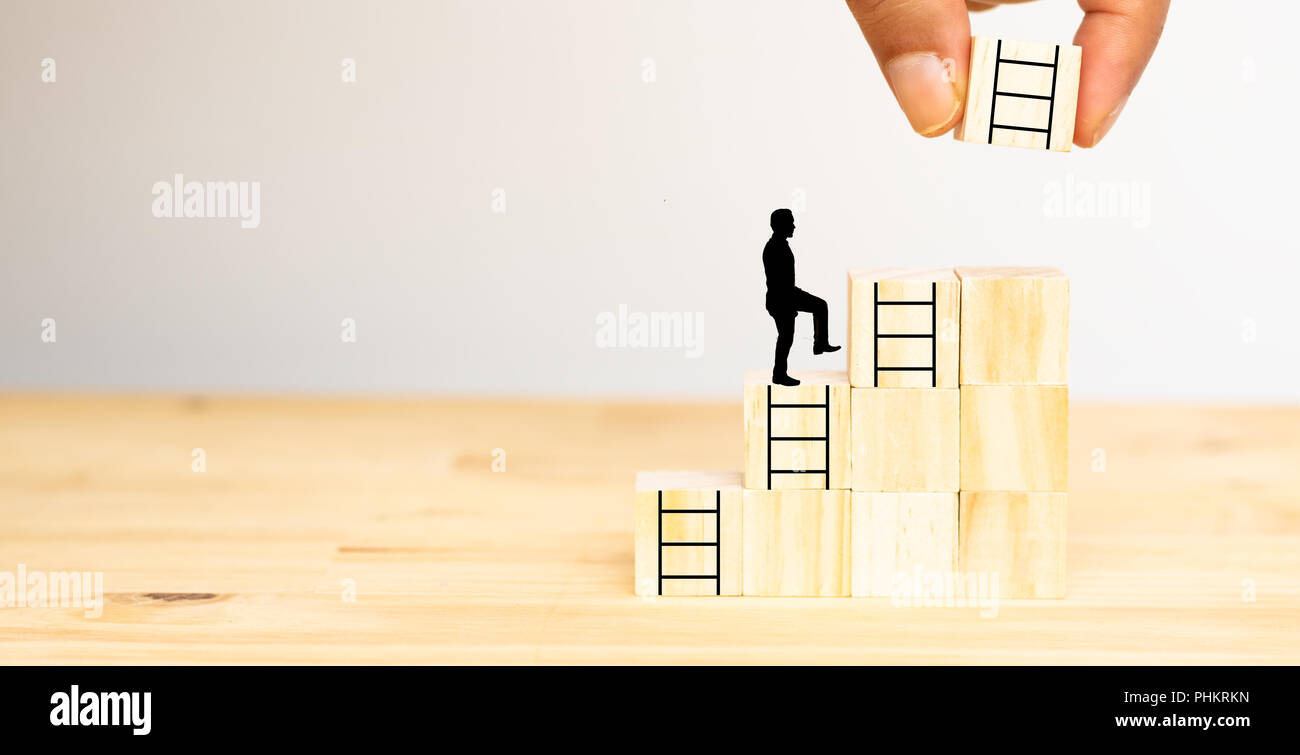 Man mano provare a mettere il prossimo gradino sui dadi di legno all'uomo per la successiva fase ,possibilità, lavoro ,azienda,successo ,progetto ,obiettivo Foto Stock