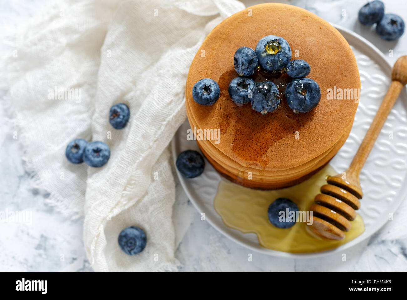 Pila di frittelle con miele e mirtillo. Foto Stock