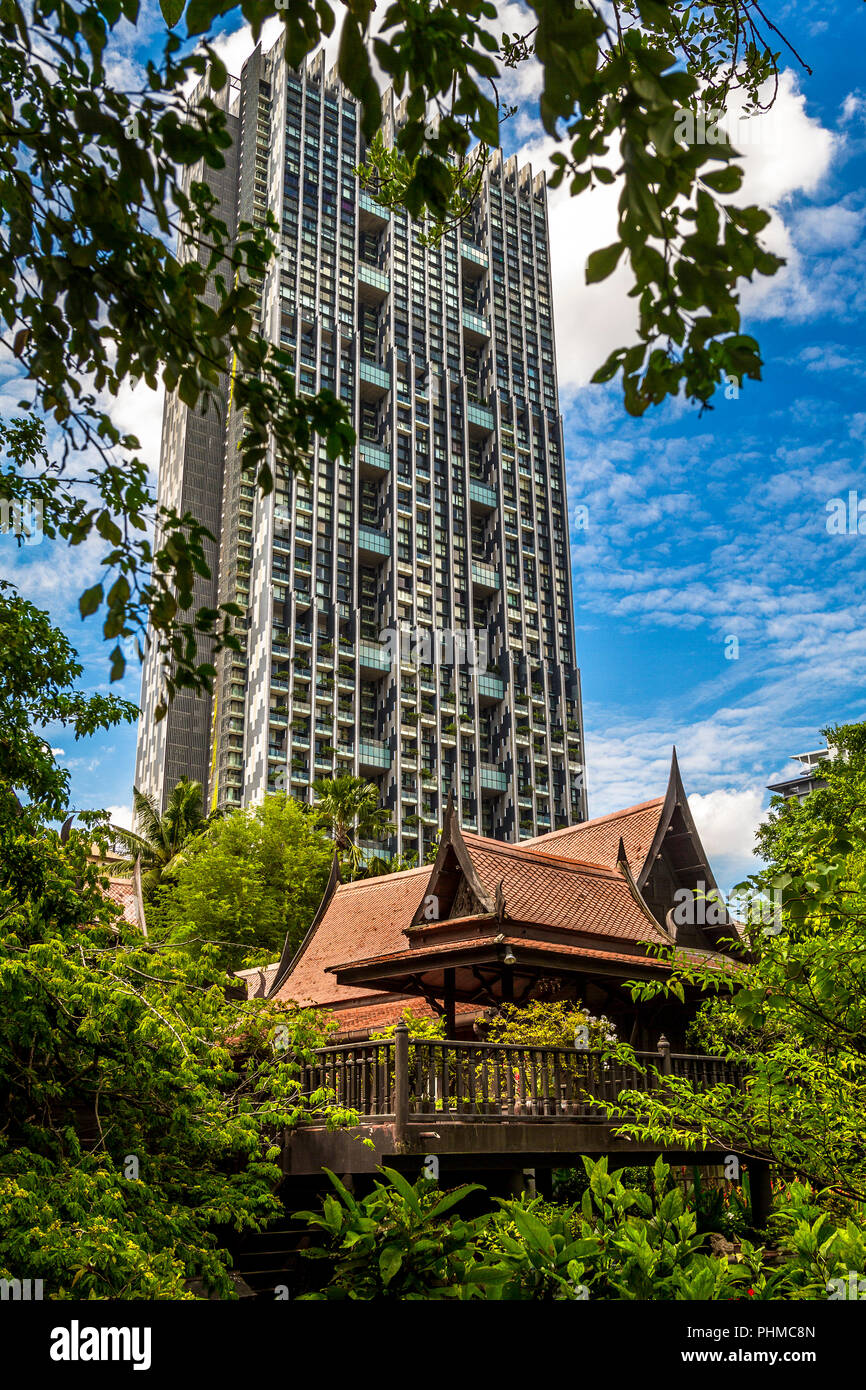 Sathorn House sopraffatte da un alto luogo in background. Una delle più grandi aree senza alta sorge nella zona Sathron di Bangkok. Foto Stock