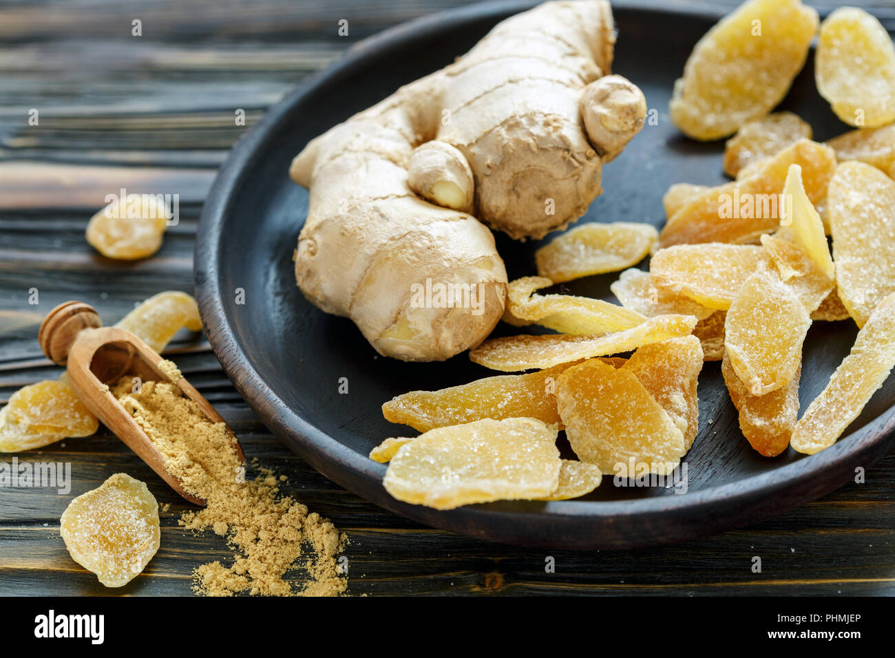 Radice di Zenzero e zenzero candito su una lastra di legno. Foto Stock