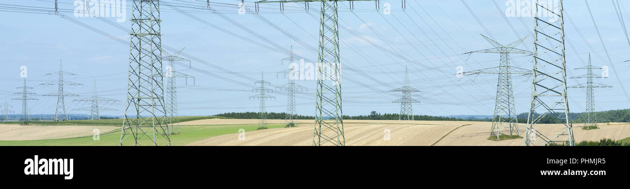 Molti piloni ad alta tensione per il trasporto di elettricità da una centrale elettrica Foto Stock