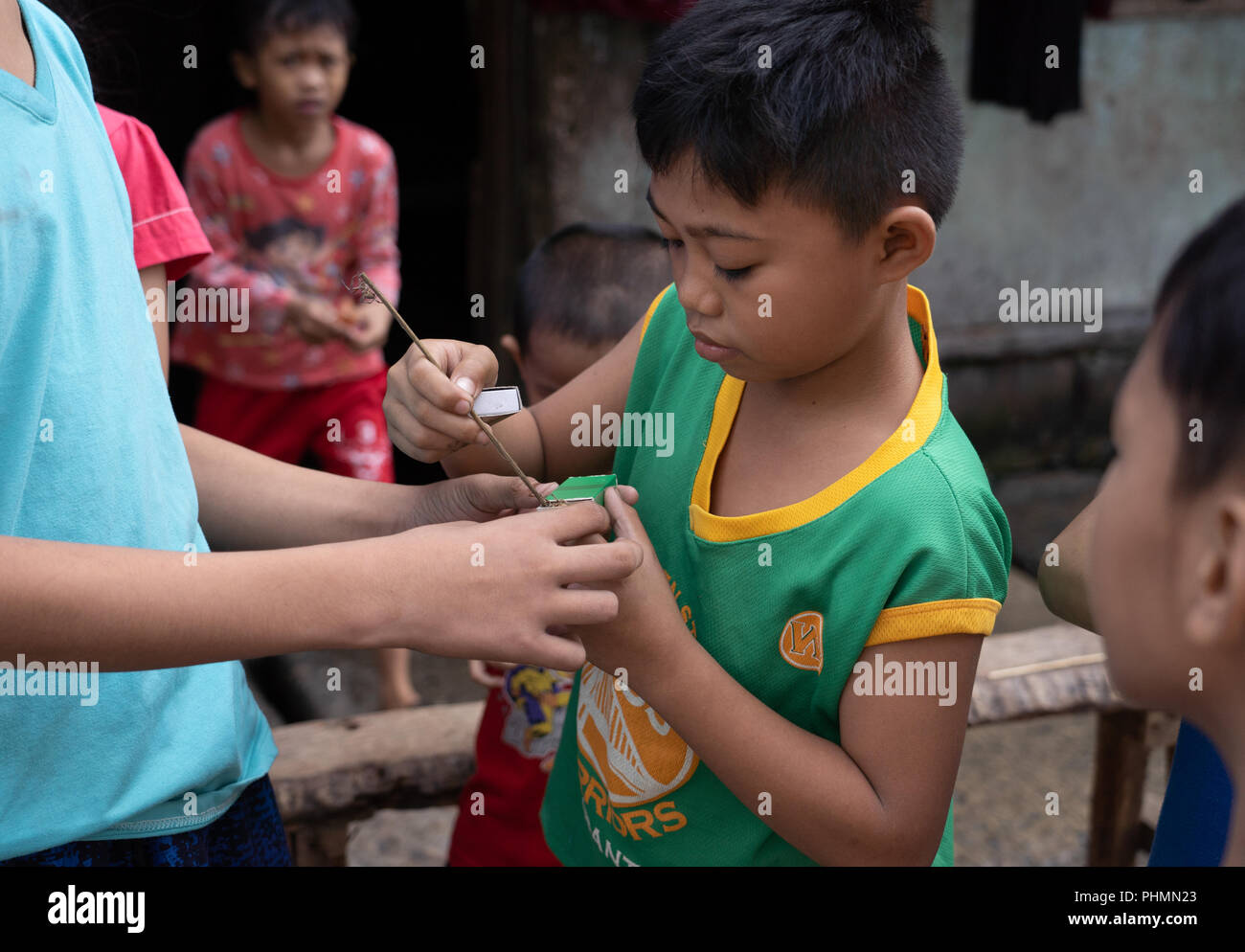 Bambini filippini condivideranno il popolare gioco di combattimenti a ragno. Foto Stock