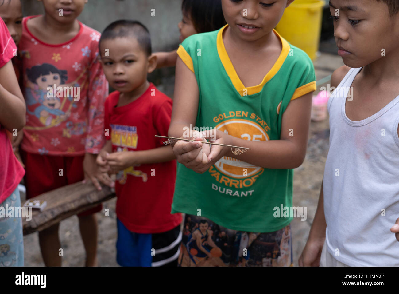 Bambini filippini condivideranno il popolare gioco di combattimenti a ragno. Foto Stock