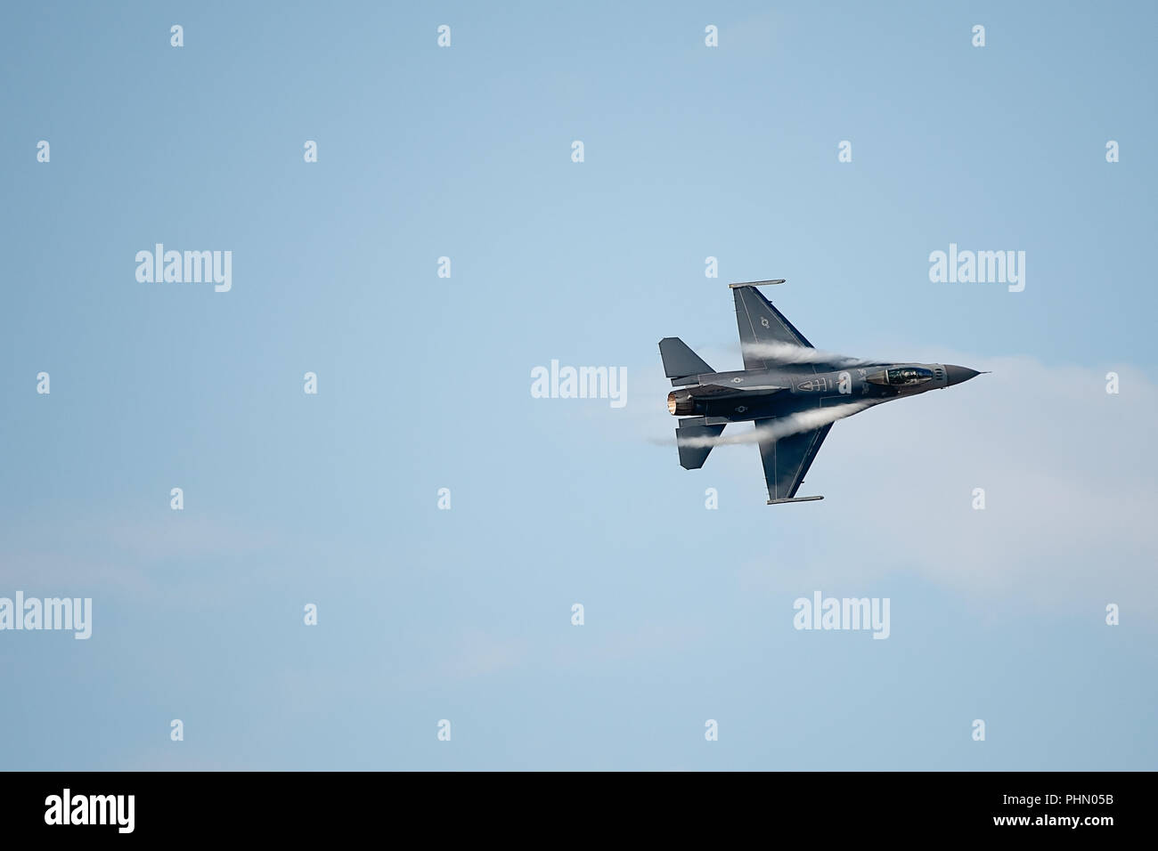 Oshkosh, WI - 28 Luglio 2018: un F-16 flying falcon di iniziare a girare con contrails iniziando a venire oltre le ali all'Airshow di CEA. Foto Stock