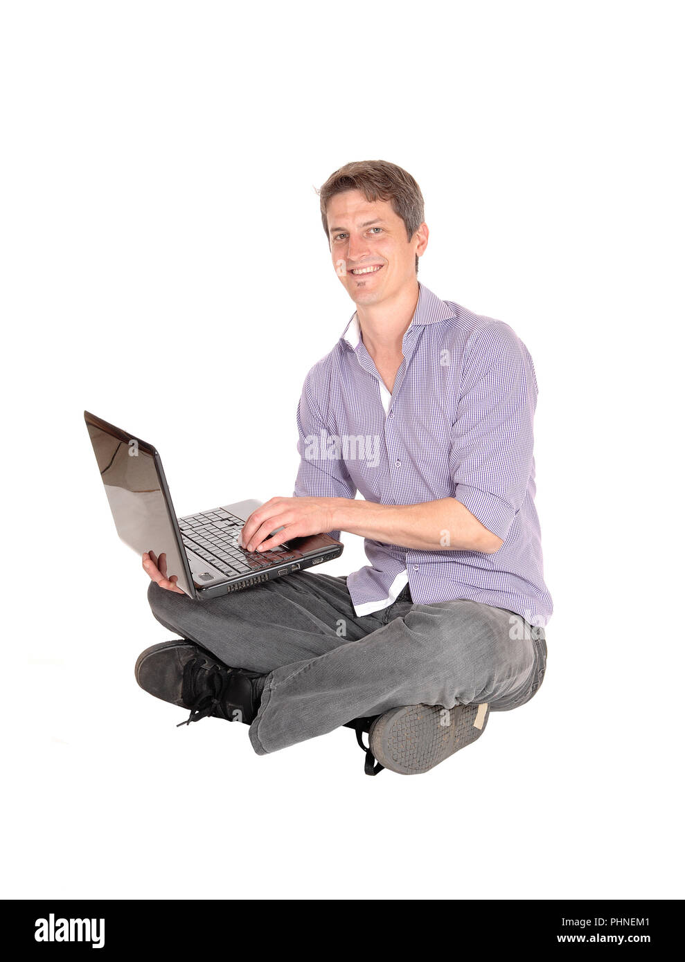 Uomo al lavoro su laptop sul pavimento Foto Stock