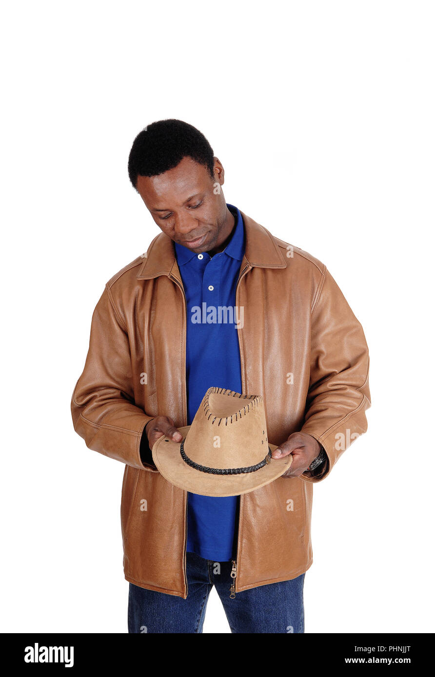 Uomo bello in giacca di pelle marrone tenendo il suo cappello Foto Stock