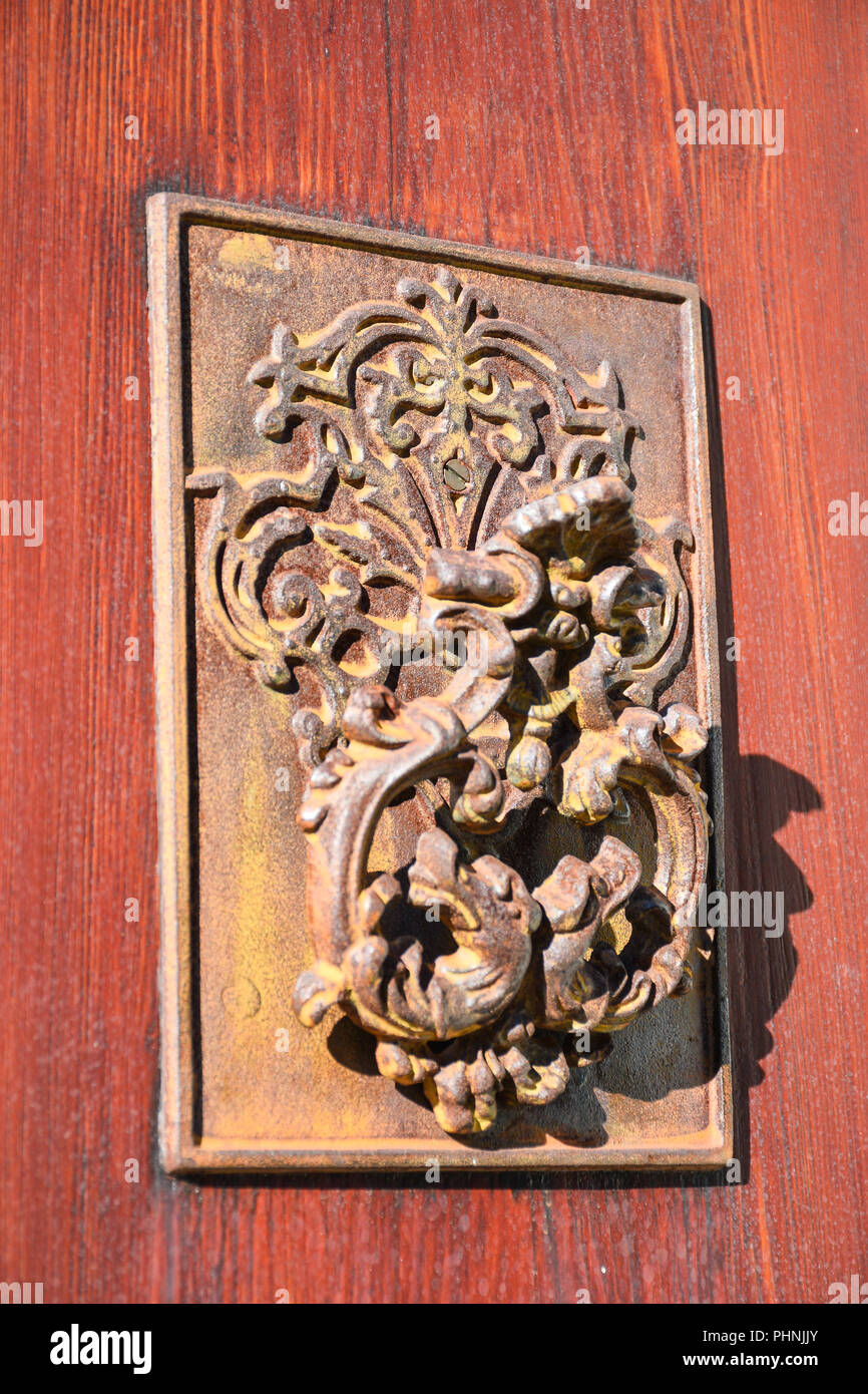 Close-up di Rusty antichi respingente porta sulla porta di legno Foto Stock