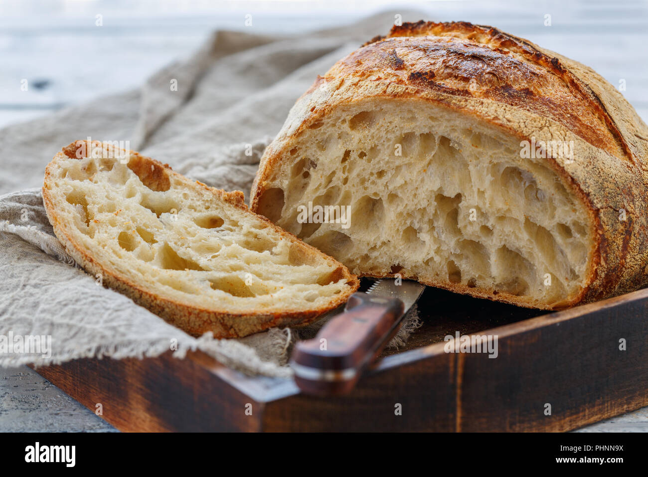 Tagliare focaccia di grano artigianale pane sulla pasta madre. Foto Stock