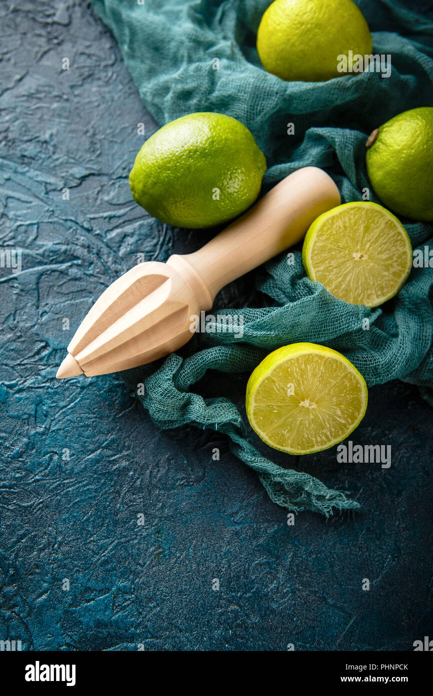Limette fresche con spremiagrumi stick. Foto Stock