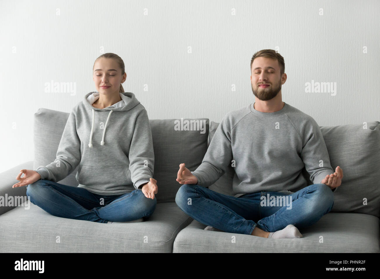 Calma giovane meditando la pratica dello yoga sul lettino insieme Foto Stock