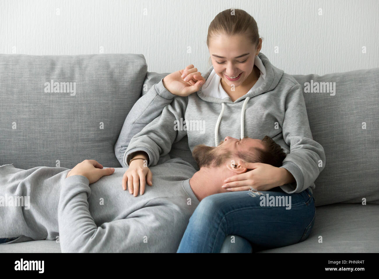 Sorridente ragazza carezza rilassante amante in ginocchio sul lettino Foto Stock