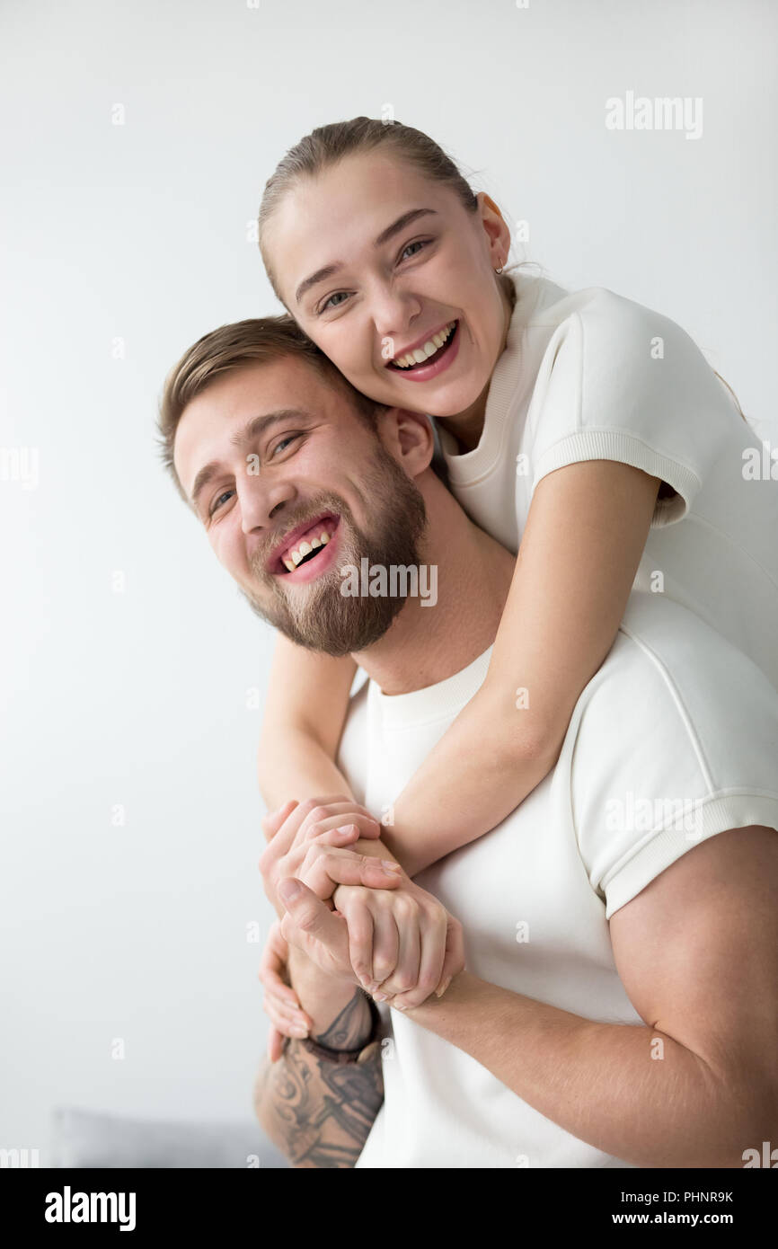 Ritratto di sorridente ragazza piggyback tatuato fidanzato Foto Stock