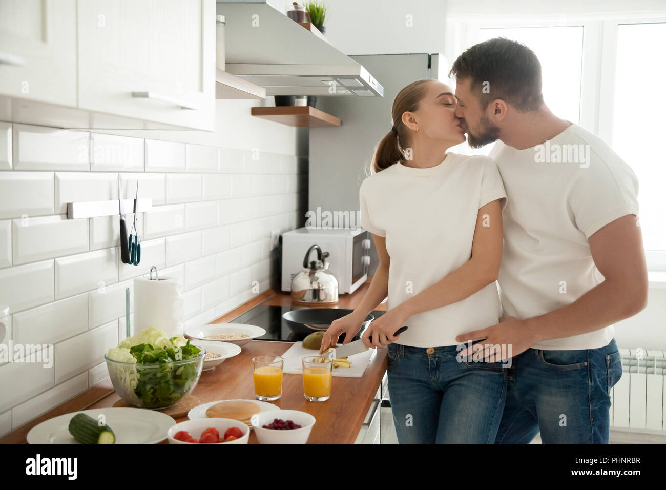 Coppia romantica inizia a baciare la cottura insieme per la prima colazione Foto Stock