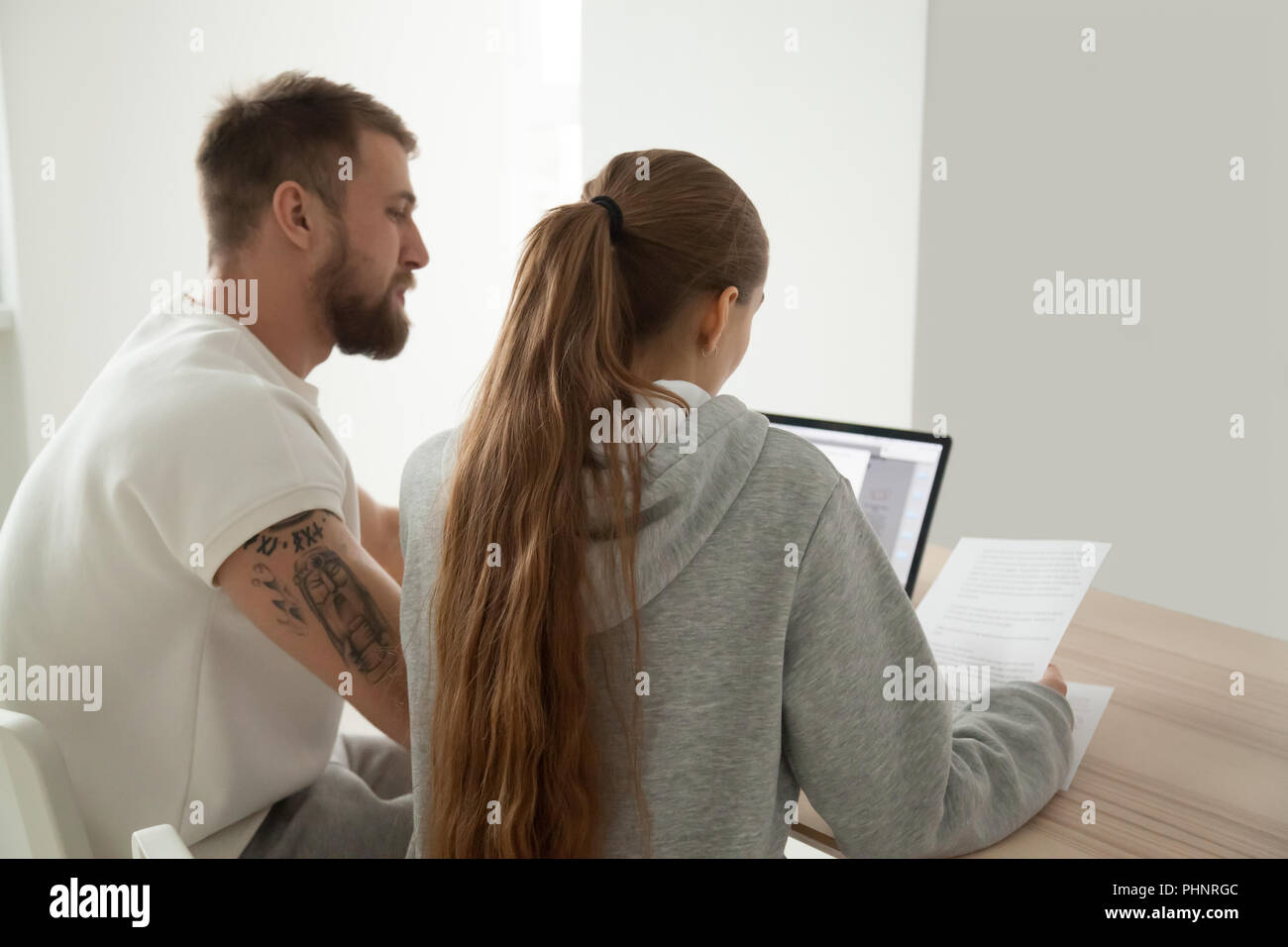 Grave coppia giovane la lettura di lettere analizzando i documenti su carta Foto Stock