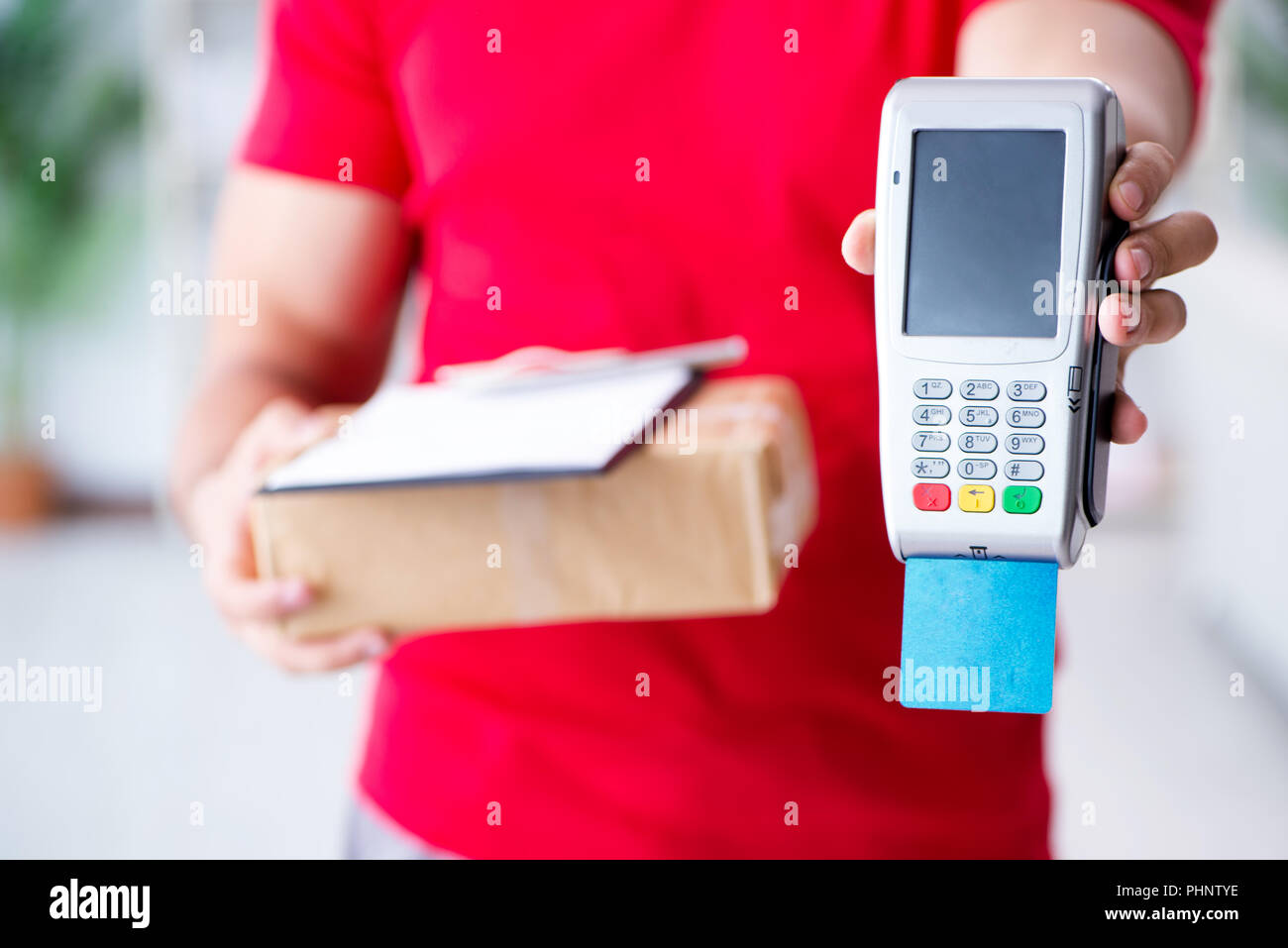 La consegna di pacchi essendo pagato con pos e carta di credito Foto Stock