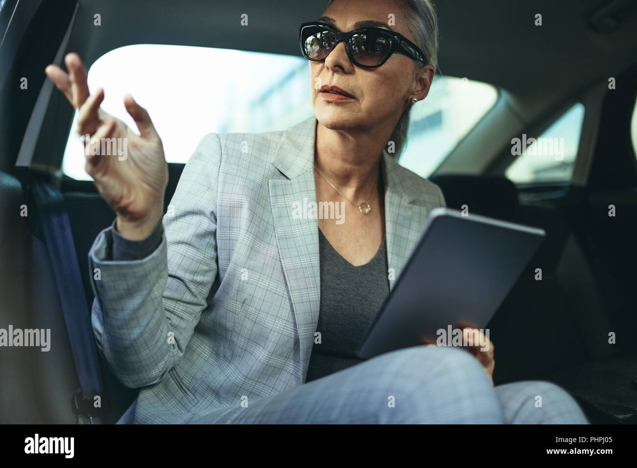 Bella coppia imprenditrice seduta sul sedile posteriore di una macchina e guardando fuori dalla finestra. Femmina executive aziendali che viaggiano da un'auto. Foto Stock