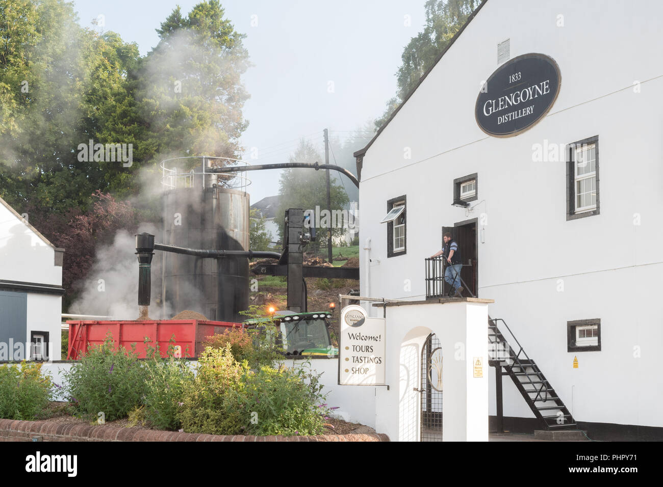 La cottura a vapore trascorso granella - un sottoprodotto del whisky processi decisionali dopo "incenerimento" - essere versata in un rimorchio a Glengoyne Distillery, Scotland, Regno Unito Foto Stock