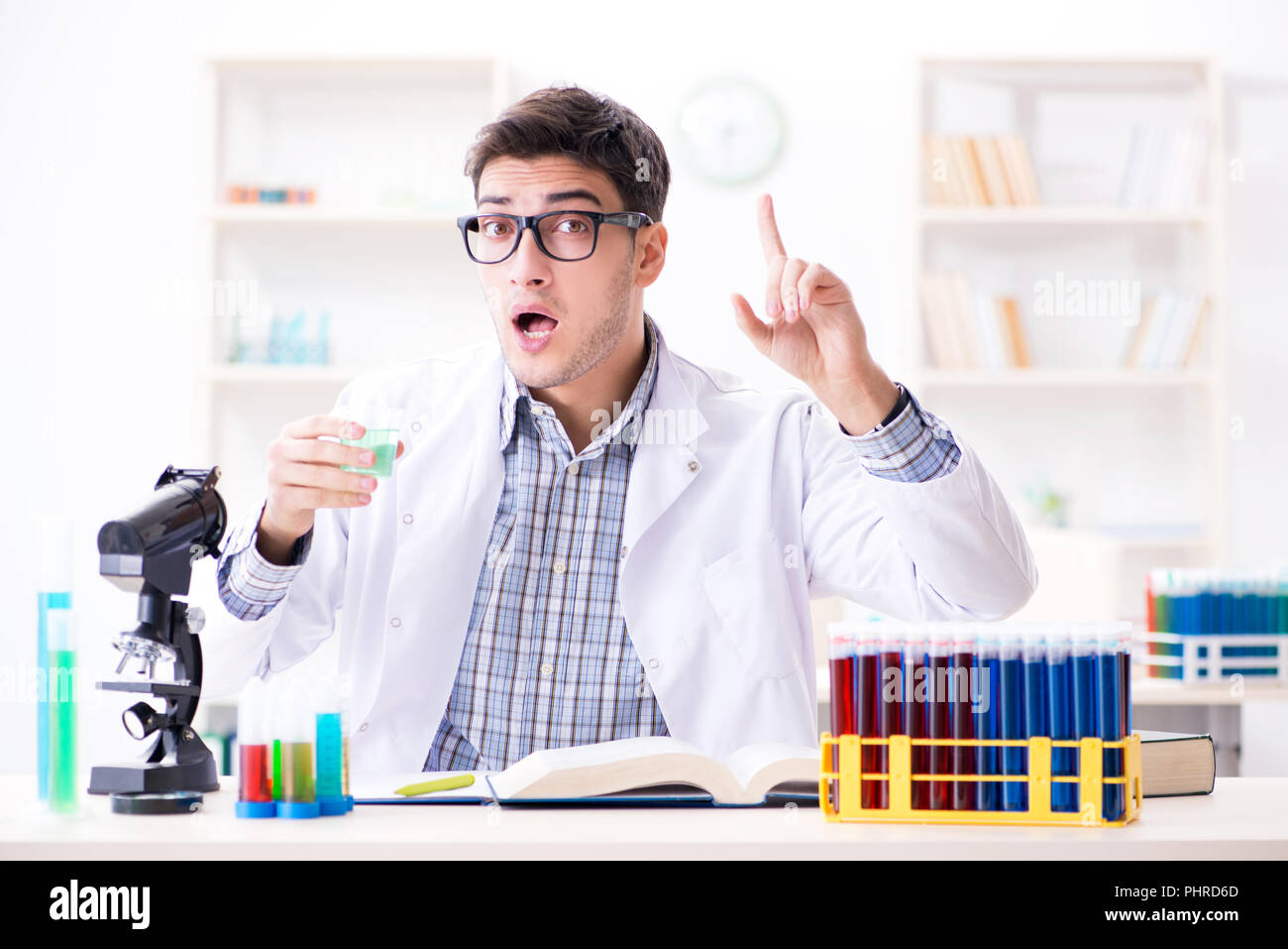 La chimica studente facendo esperimenti di chimica a activi in aula Foto Stock