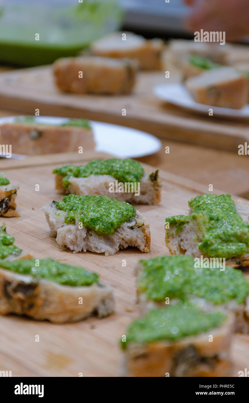 Pane fresco e pesto di basilico su marrone tavolo in legno Foto Stock