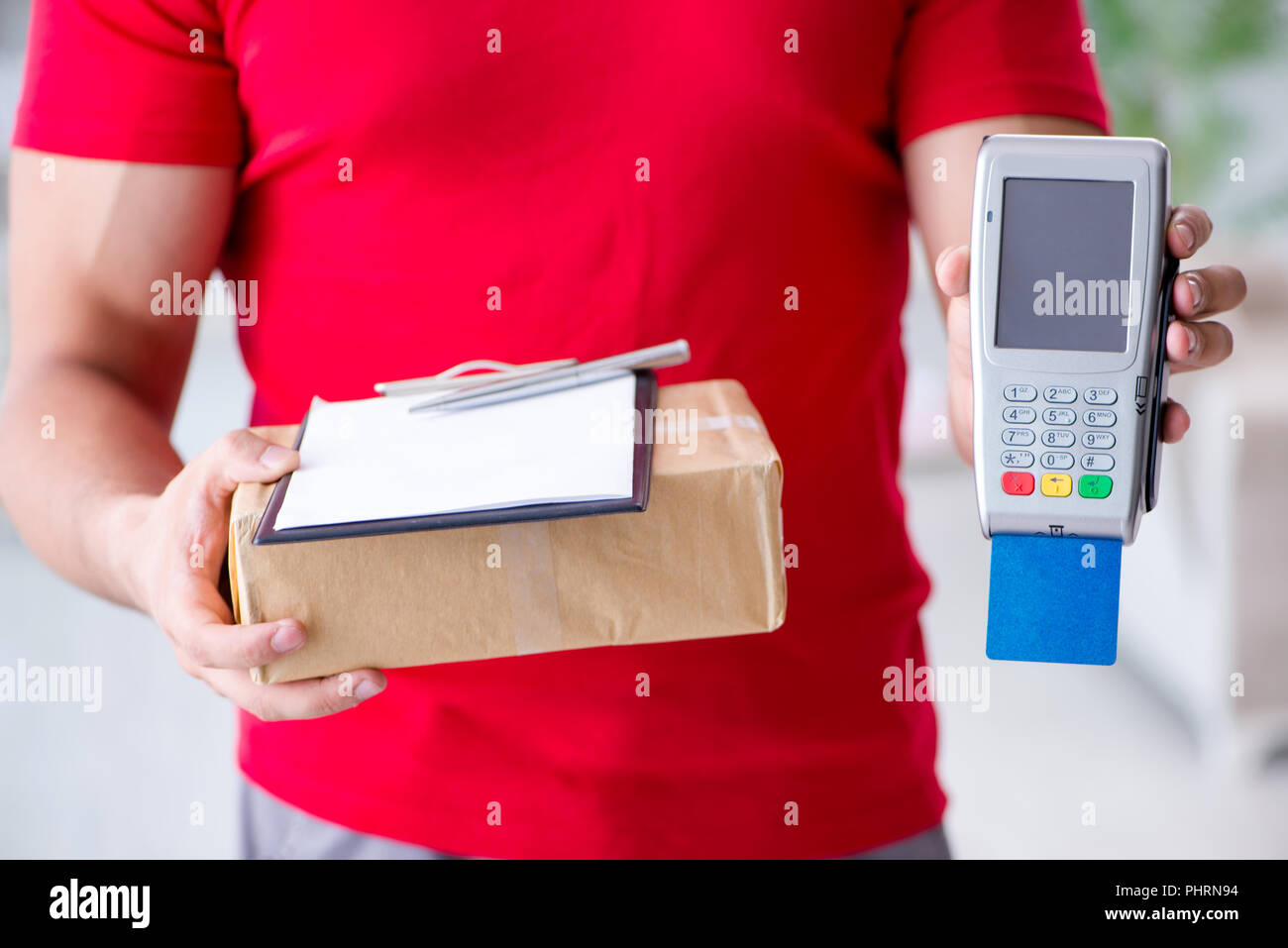 La consegna di pacchi essendo pagato con pos e carta di credito Foto Stock
