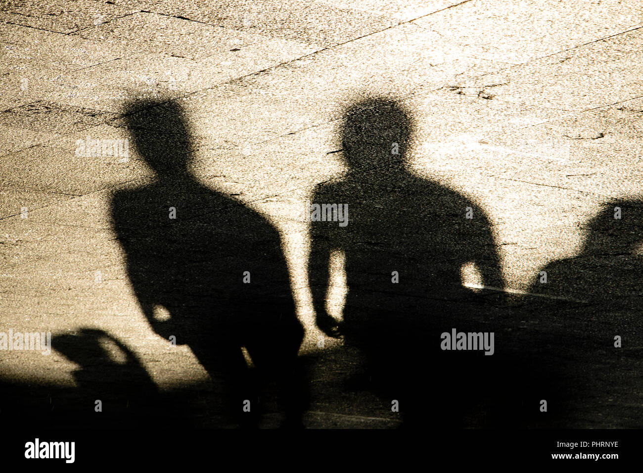 Le ombre sagome di un gruppo di uomini in piedi sul lungomare di estate in seppia in bianco e nero Foto Stock