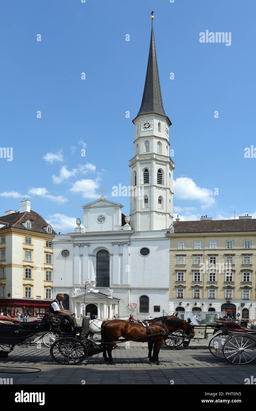 Chiesa di St. Michael con il tradizionale carrozze Fiaker sul San Michele square a Vienna - Austria. Foto Stock