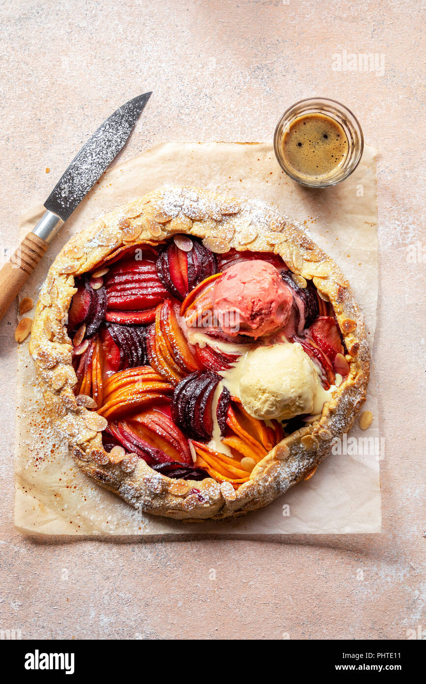 Pane appena sfornato frutta a nocciolo galette con due una cucchiaiata di gelato sulla parte superiore Foto Stock