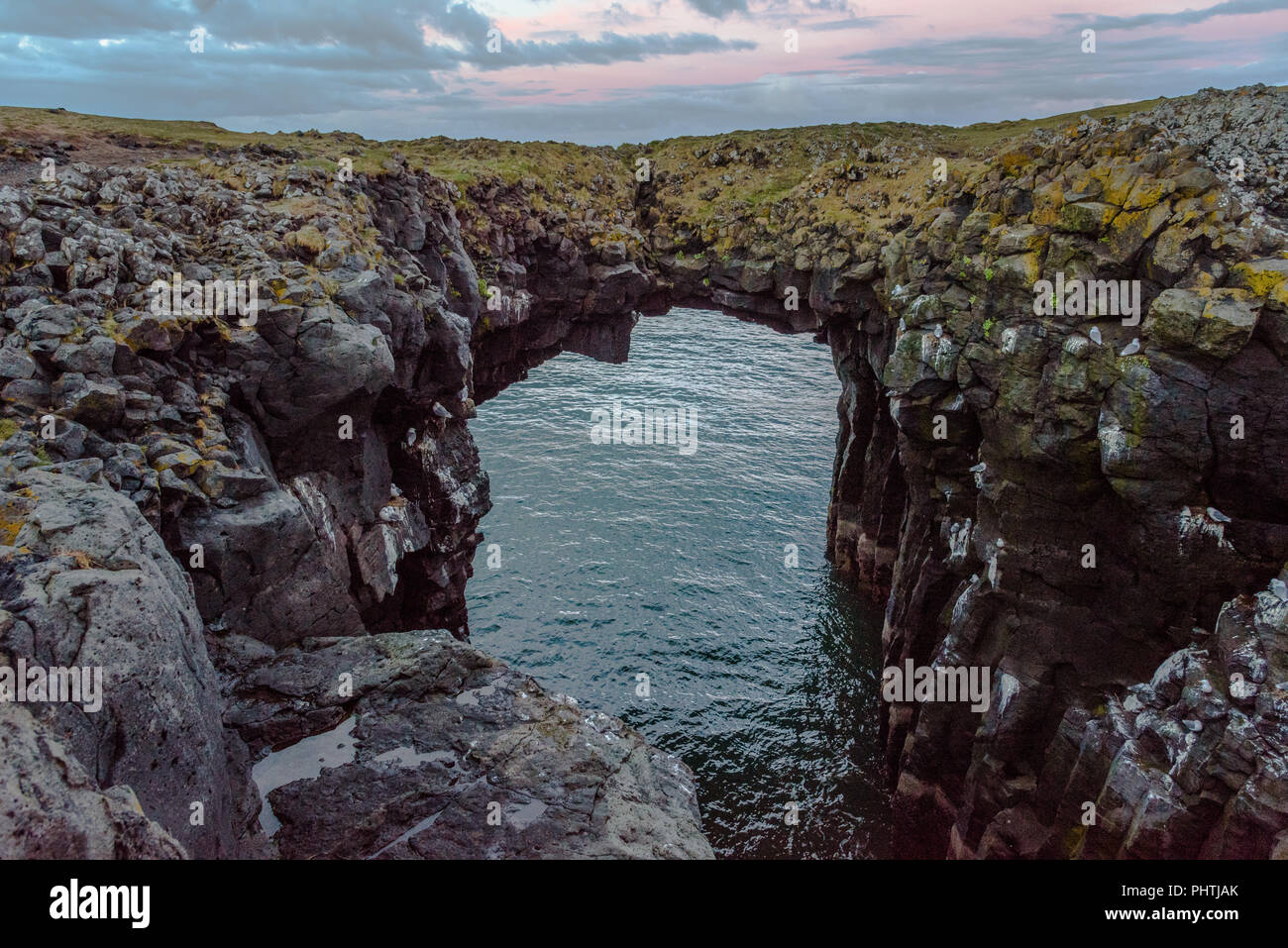 La pietra naturale a ponte Arnarstapi sulla penisola Snaefellsnes in Islanda al crepuscolo Foto Stock