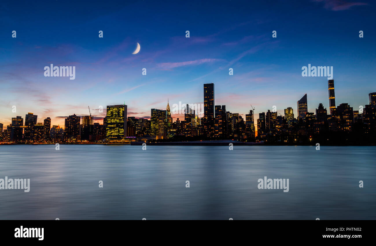 New York skyline di notte con la falce della luna nel cielo Foto Stock