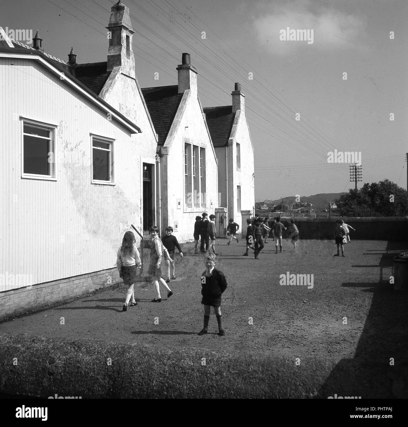 Anni sessanta, foto storiche dei figli fuori a scuola di Lochboisdale, Sud Uist, Ebridi Esterne, Scotland, Regno Unito. Foto Stock