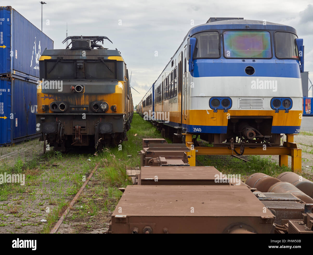 Linee di vecchi treni, sia diesel e elettrico memorizzato al Marine contenitore porta in attesa di smaltimento, Olanda. Foto Stock