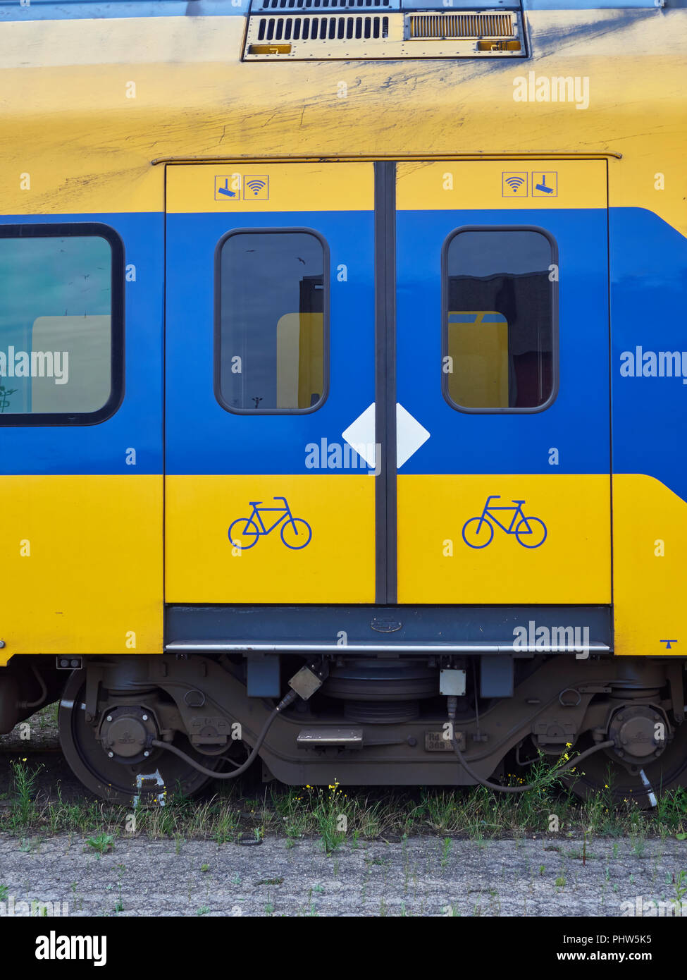 Close up dettaglio delle porte scorrevoli associati e le marcature di sicurezza sui vecchi urbano Ferrovie olandesi vani passeggeri memorizzati in corrispondenza del terminale per container Foto Stock