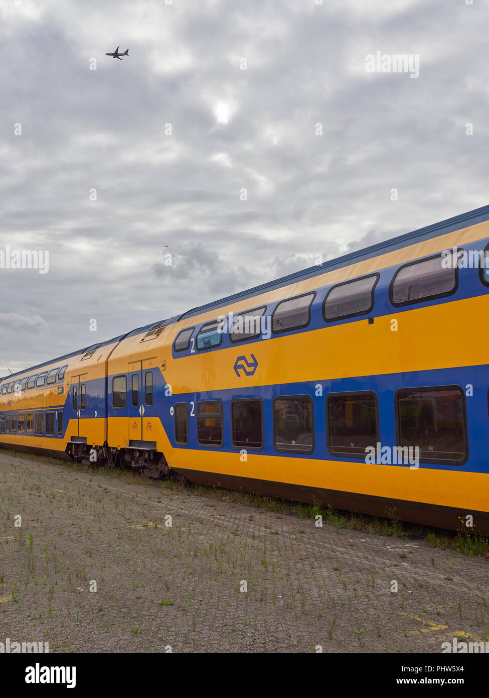 Carrozze passeggeri dal Dutch Urban compagnie ferroviarie in linea su binari in corrispondenza di un terminale per container in Den Haag, Paesi Bassi. Foto Stock