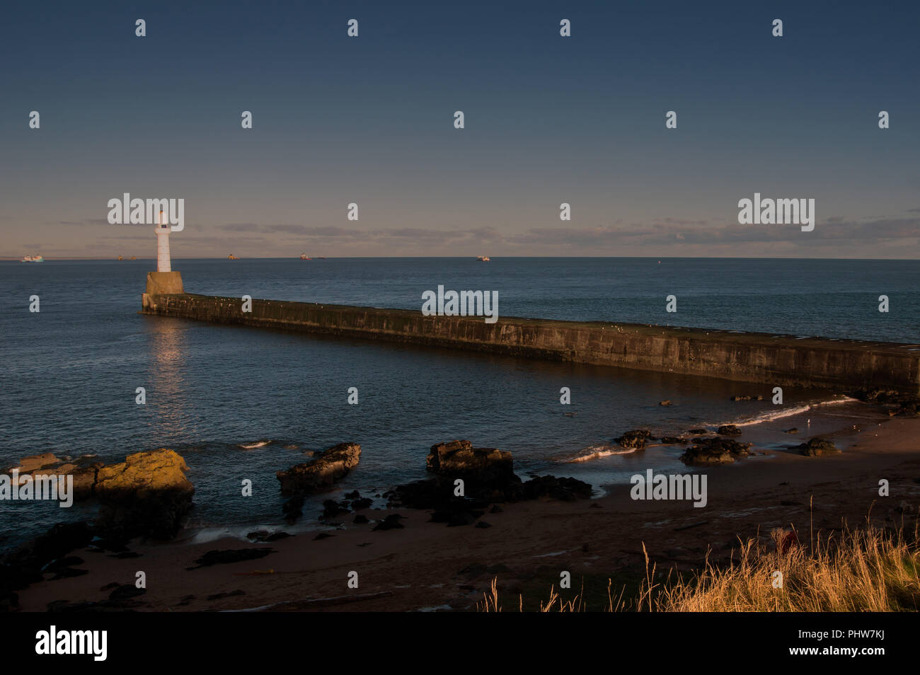 Casa di luce sulla parete del porto in entrata al porto di Aberdeen in Scozia Foto Stock
