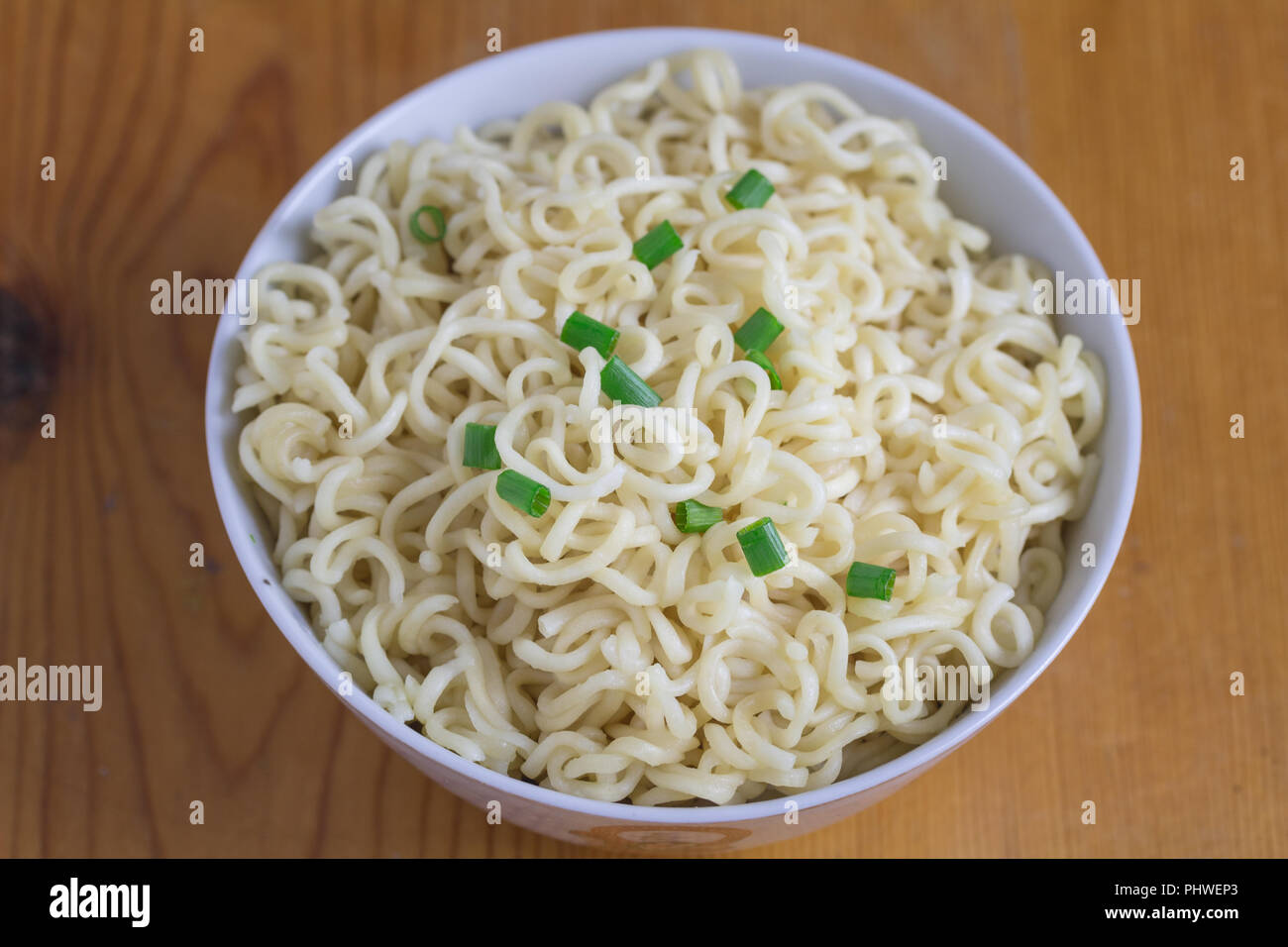 Tagliatelle in recipiente isolato su un tavolo di legno con il fuoco selettivo su tagliatelle Foto Stock