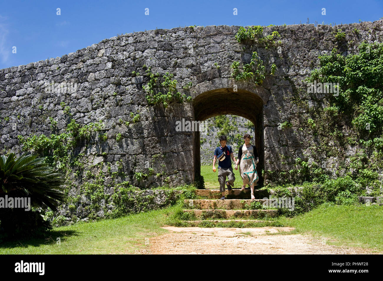 Visitatori uscire dal cancello principale del castello Zakimi rovine nel villaggio di Yomitan, Prefettura di Okinawa, in Giappone, il 20 maggio 2012. Costruito tra il 1416 e il 1422 dal Foto Stock