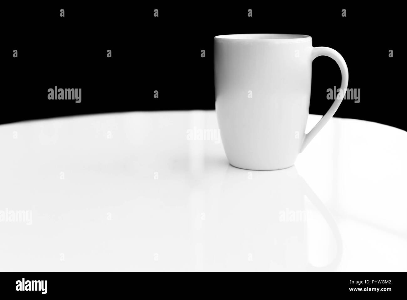 Bianco di ceramica tazza vuota vuota per un caffè o un tè sul tavolo bianco Foto Stock Bianco di ceramica tazza vuota vuota per un caffè o un tè sul tavolo bianco Foto Stock