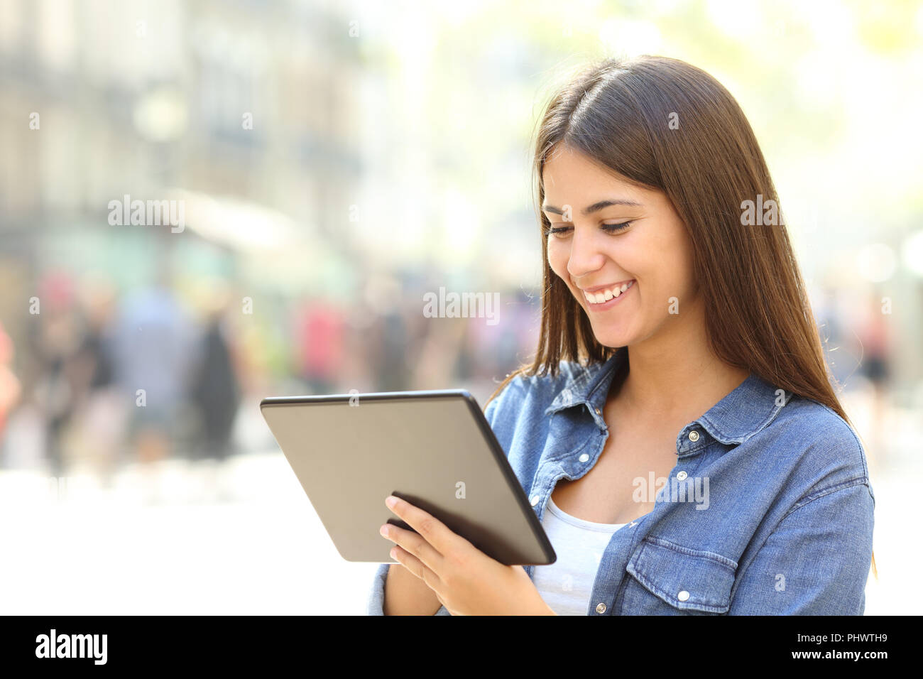 Unico felice teen utilizza un tablet per cercare i contenuti online in strada Foto Stock
