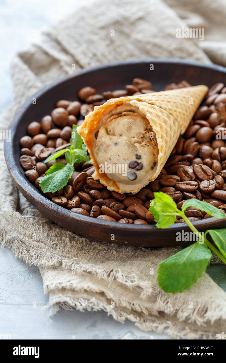Gelato al caffè con gocce di cioccolato in un cono di cialda. Foto Stock
