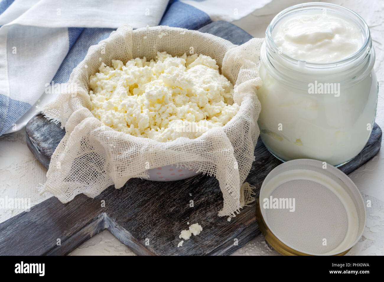 Per la ricotta in una ciotola e vaso di latte acido. Foto Stock