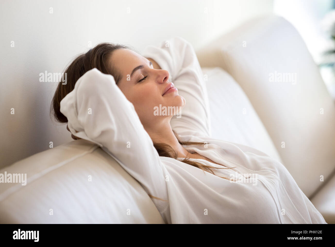 Calma millenaria donna relax su un comodo divano respirando fre Foto Stock