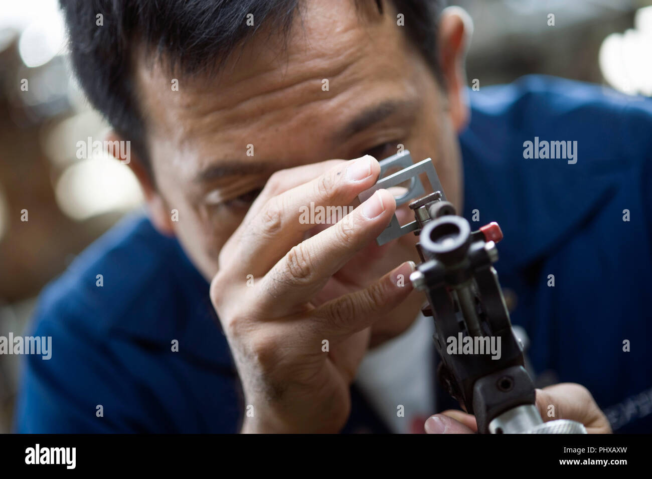 Kazuhito Komatsu, presidente di Komatsu fabbrica di taglio, guarda a pietre preziose elaborati presso la sua azienda nel Kofu City, Prefettura di Yamanashi, Giappone Foto Stock