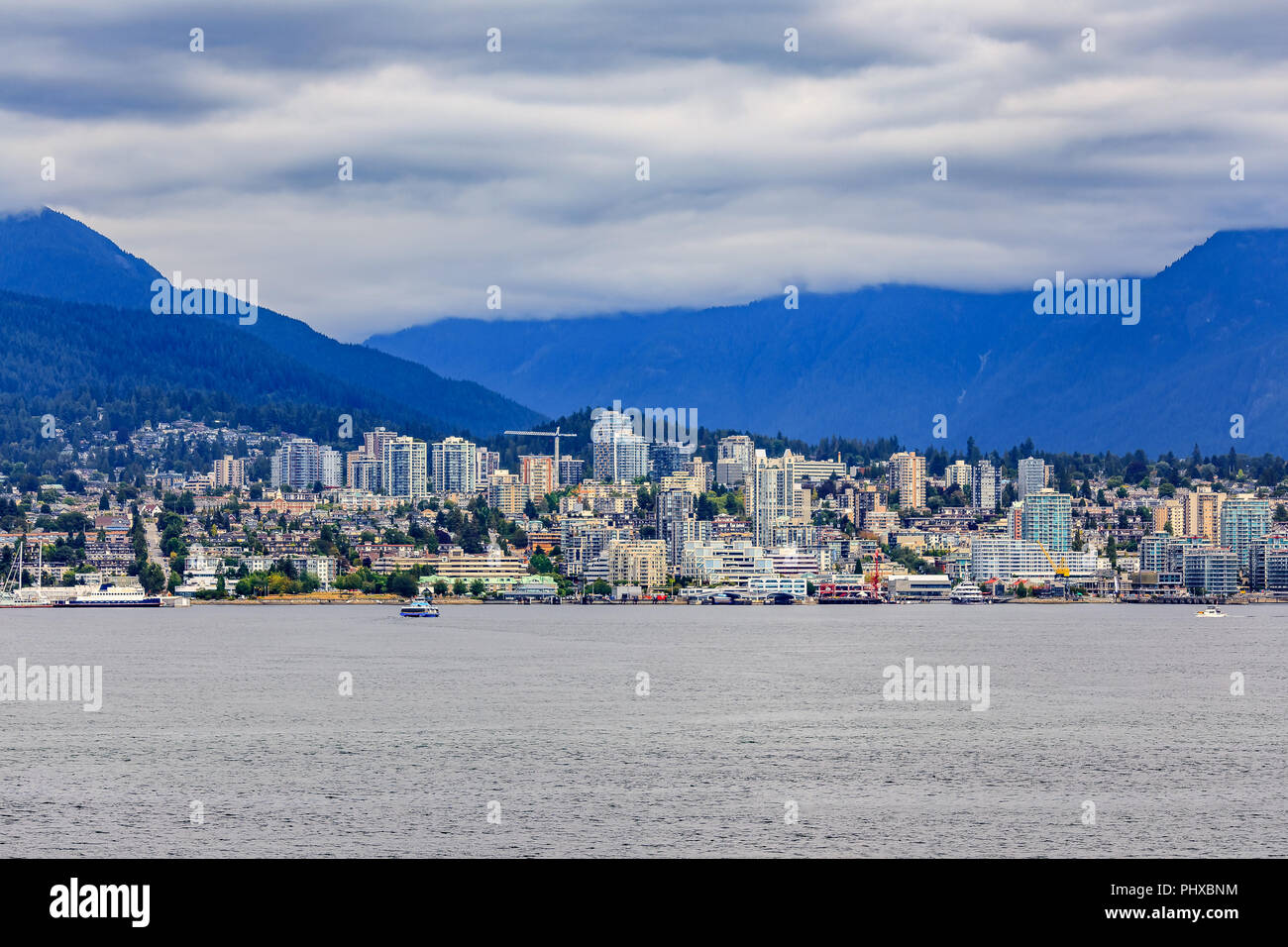 Vancouver North Shore skyline e waterfront cityscape con Grouse Mountain in un giorno nuvoloso in British Columbia, Canada Foto Stock