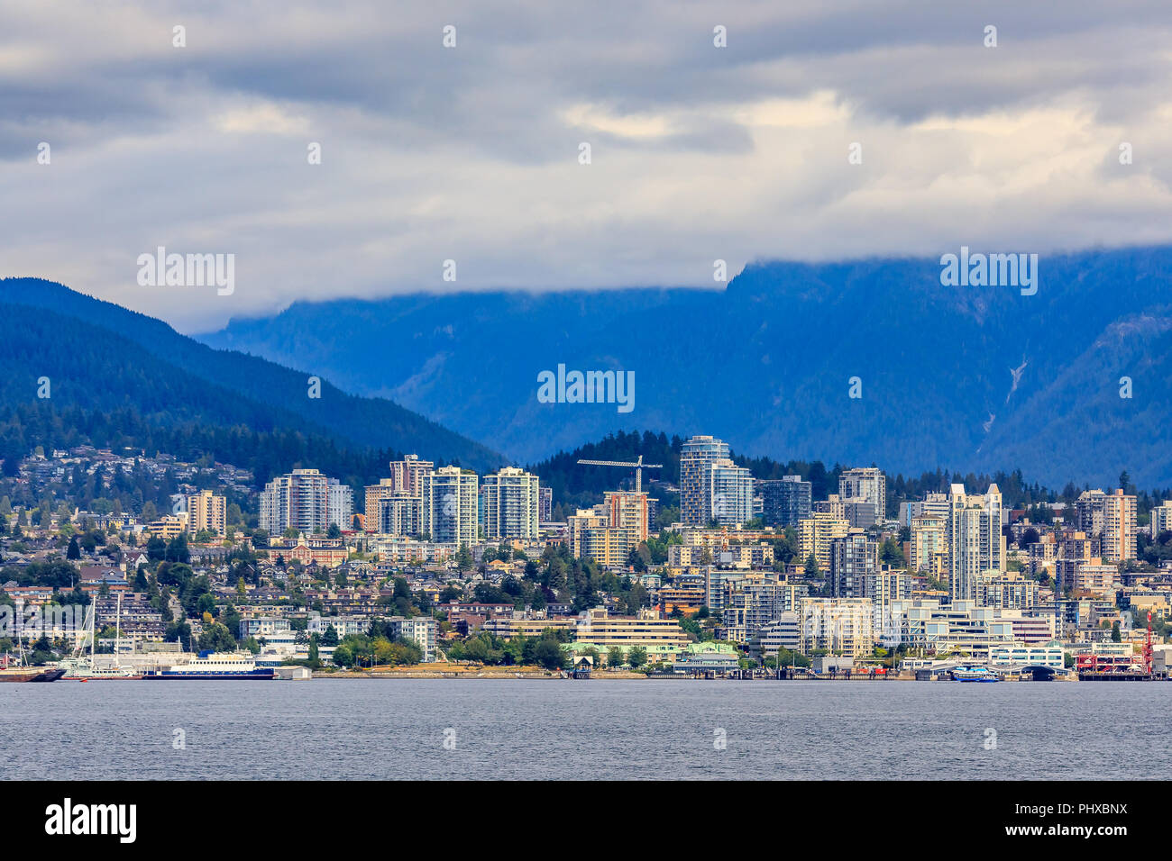 Vancouver North Shore skyline e waterfront cityscape con Grouse Mountain in un giorno nuvoloso in British Columbia, Canada Foto Stock