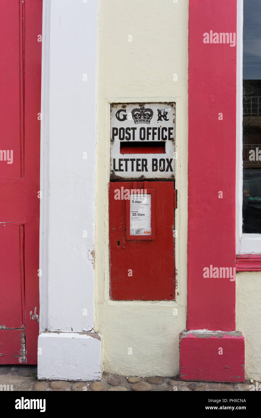 Red GR post box set in una parete in High Street , Kimbolton, Cambridgeshire, Regno Unito Foto Stock